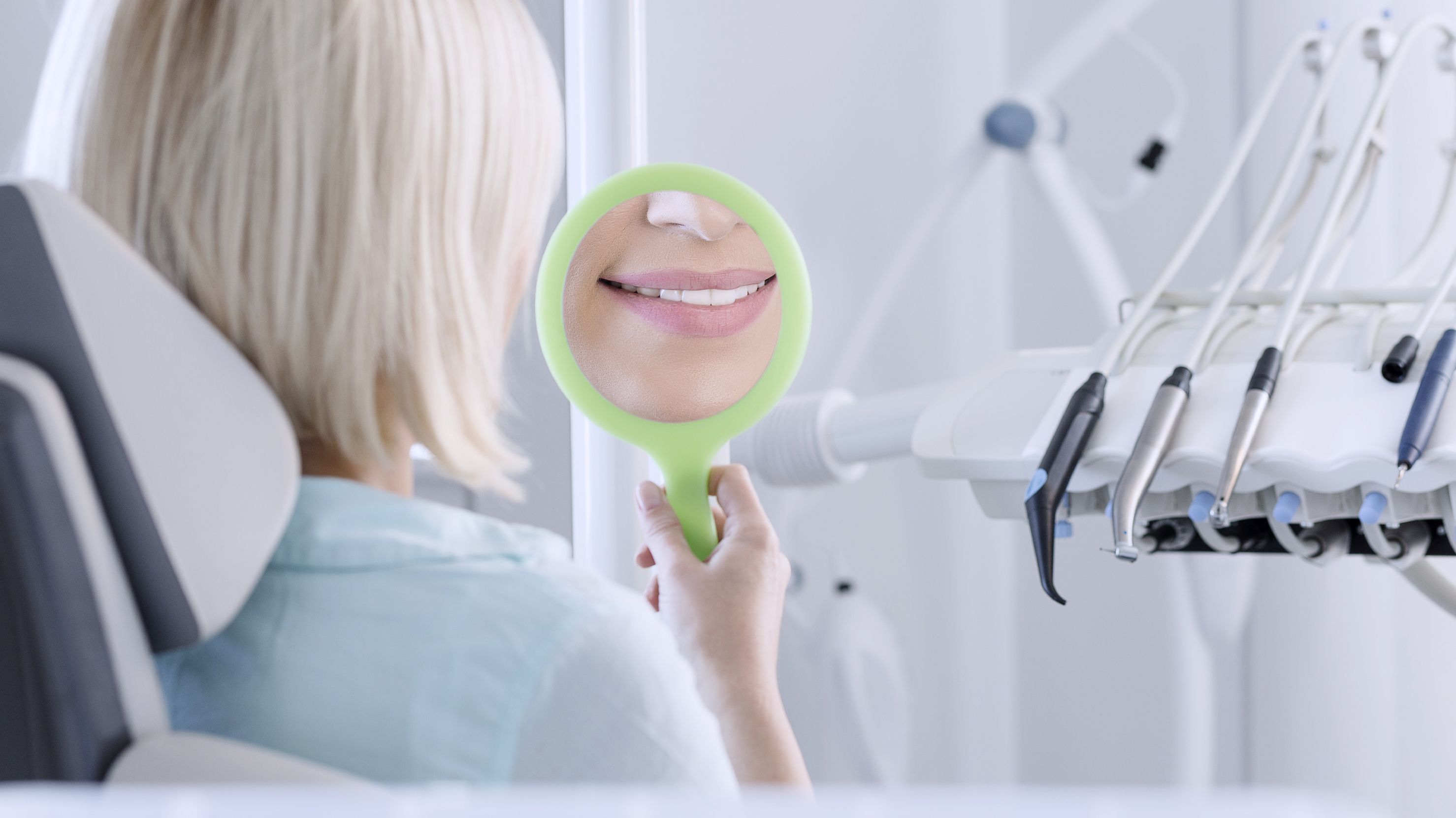 Photo of a woman's smile in the mirror at a dentist's office